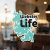 Turquoise map sticker with text Webster Life on a reflective surface.