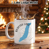 White mug with Redfish Lake, Idaho design, set by a fireplace and Christmas tree.