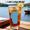 Glass of iced tea with Lake Tahoe shape on it, beside a book.