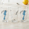 Three clear glasses with a blue lake shape and compass rose design.