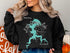 Black sweatshirt with "Beautiful Grassy Lake Illinois" and compass graphic.