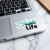 "Ouachita Life" sticker on a laptop with a teal lake outline.
