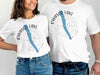 White t-shirts with "Owasco Lake" and a compass design with a blue outline of the lake.