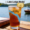 Glass of iced tea with "Lake Lodge Media" and compass design on wooden table