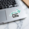 Turquoise James Life sticker with lake outline on a laptop.