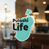 Pulaski Life sticker with turquoise background and black text on a glass surface.