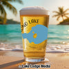 Glass of beer with "Mono Lake California" design on beach background.