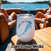 A white insulated wine tumbler with a Lake Las Vegas design sits on a wooden boat table.