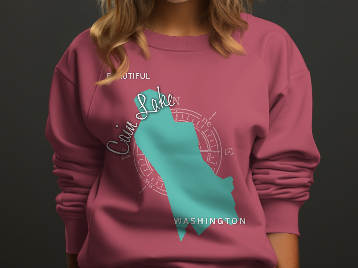 Teal "Cain Lake" graphic on pink sweatshirt with compass rose.