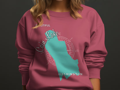 Teal "Cain Lake" graphic on pink sweatshirt with compass rose.