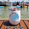 A white stainless steel insulated tumbler with a Lake Simcoe graphic sitting on a wooden boat deck.