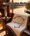 Woven blanket with Shuswap Lake, British Columbia map design on leather sofa.