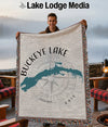Buckeye Lake map and compass design on a fringe blanket held by a smiling man.
