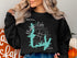 Black sweatshirt with turquoise map of Medina Lake, Texas, and compass rose.