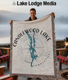 Man holds a woven throw blanket with a compass design and "Candlewood Lake Connecticut" text.