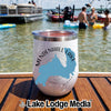 White stainless steel tumbler featuring a blue Mendenhall Lake, Alaska graphic, standing on a wooden boat deck with a lake and boats in the background.