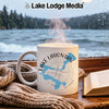 White mug with Lake Lahontan Nevada design and compass on a rainy window sill.