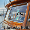 Leelanau Life sticker on a wooden boat window with Lake Lodge Media logo.