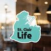 Teal sticker with "St. Clair Life" in black text, adhered to a glass surface.