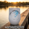 White stemless wine tumbler with a blue map of Lake Charles, Ontario, and a compass design sitting on a wooden dock.