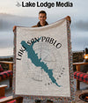 Woven blanket with Lake San Pablo map and compass design, held by a man.