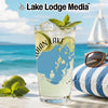Glass of drink with lime and mint on beach with sailboat in background.