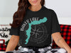 Black t-shirt graphic reads "Baker Lake Washington" with a turquoise lake shape and compass rose.
