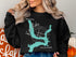 Black sweatshirt with a turquoise map of Kaw Lake, Oklahoma and compass rose.