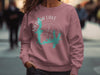 Pink crewneck sweatshirt with Medina Lake Texas graphic and compass rose design.