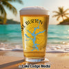 Glass of beer with Lake Burton Georgia map and compass on beach backdrop.