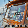 Window sticker with Canandaigua Life, Lake Lodge Media text on a wooden boat.