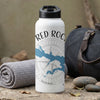 White water bottle with "RED ROCK" text and compass design, next to a rolled towel and duffel bag.