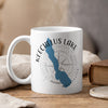 White mug with blue Keechelus Lake map and compass design, steam rising.
