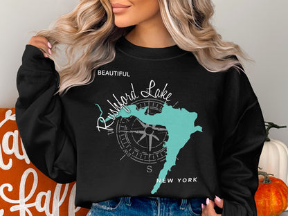 Black sweatshirt with a teal map of Rushford Lake, New York and compass.