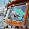 Teal Garibaldi Life sticker on a wooden boat window, with "Lake Lodge Media" logo.