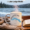 White mug with "Rainbow Lake Maine" and compass design, steam rising.