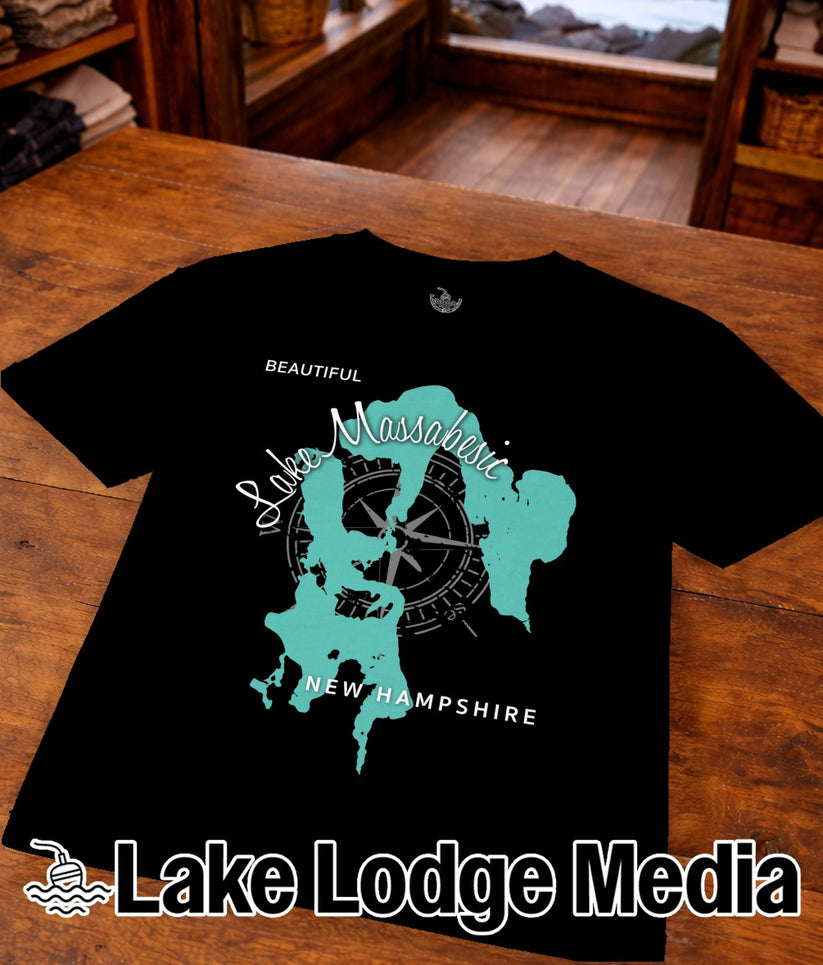 Black t-shirt with a turquoise outline of Lake Massabesic and compass.