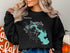 Black sweatshirt with a teal Lake Livingston map and compass rose design.
