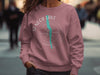 Pink sweatshirt with "Seneca Lake, New York" compass graphic and teal lake outline.