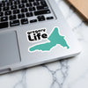 Gregory Life sticker with turquoise map shape on a laptop keyboard.