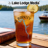 A tall glass of iced tea with a lemon slice, printed with Lake Barkley graphics, on an outdoor table.