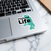 Flathead Life sticker on a laptop keyboard with a teal lake outline.