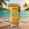 Glass of beer with "Mark Twain Lake" design on a sandy beach.