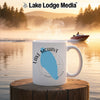 White mug with "Lake Mohave Nevada" design in front of a misty lake sunrise scene.