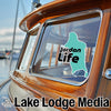 Teal Jordan Life sticker on a boat window, text "Lake Lodge Media" below.