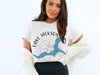 White t-shirt with graphic of compass and blue Lake Jackson, Georgia.