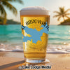 Glass of beer with "Lake Arrowhead" graphic on a beach with palm trees.