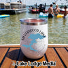A white insulated tumbler with Silverwood Lake California graphics rests on a wooden boat deck against a lake background.