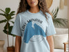 Light blue t-shirt with "LAKE MANAWA IOWA" text and blue lake outline graphic.
