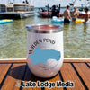 A white insulated tumbler featuring Walden Pond, Massachusetts text and a blue map silhouette on a wooden deck by a lake.